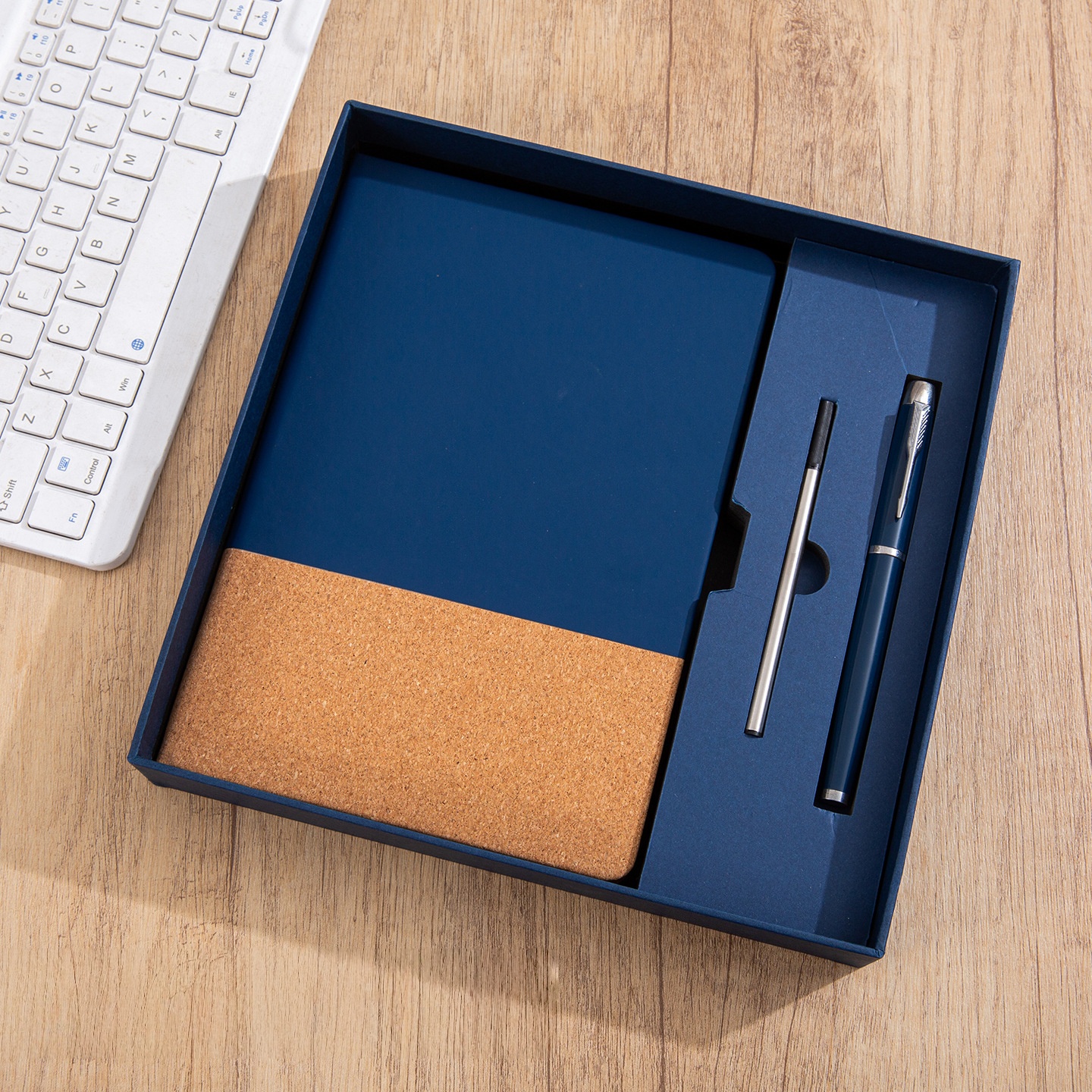 Caja de regalo con recambio de bolígrafo y cuaderno azul.