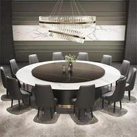 Table à manger moderne minimaliste en acier au carbone avec plateau en quartzite électrique de Foshan, pour usage domestique, sensation haut de gamme, avec chaises pivotantes centrales complètes