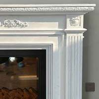 Cheminée en marbre blanc sculptée à la main avec colonne cannelée et relief floral, cadre de cheminée décoratif pour salon de villa intérieur