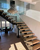 Escalier moderne à poutre simple, marches en bois et marches ouvertes, garde-corps en verre sans cadre