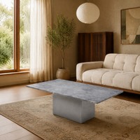 Table basse contemporaine en pierre gris clair avec base moderne en ciment, personnalisable pour les projets hôteliers et de villas