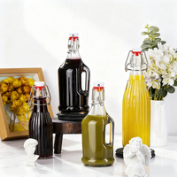 Bouteille en verre vide ronde pour jus de fruits, lait, boissons, avec couvercle à rabat et poignée