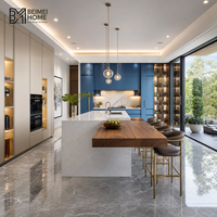 Meubles de cuisine contemporains en coton cachemire crème avec accents bleu azur, îlot de cuisine en noyer cantilevered, menuiserie de penthouse