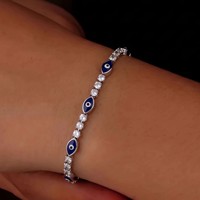 Bracelet géométrique superposé œil bleu, tendance spirituelle, empilable, style statement, succès viral sur TikTok et Instagram, mystère