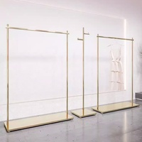 Équipement de magasin de vêtements de luxe Étagère modulaire en acier inoxydable doré Porte-robe Support d'affichage en or pour boutique