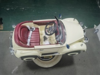 Chaise de barbier pour enfants de style rétro dans le salon, Rolls cream convertible avec siège rouge sur base brillante.