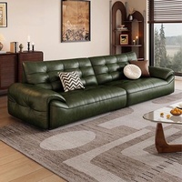 Canapé en cuir ciré vert olive style Mid-Century, capitonné, avec accoudoirs roulés et assise profonde, idéal pour petit salon ou appartement