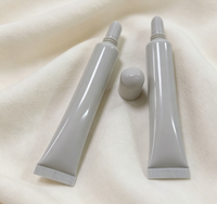 Tuyau souple en plastique extrudé pour huile à lèvres, transparent laiteux givré, avec embout biseauté et bouchon, contenant vide pour brillant à lèvres, en vrac