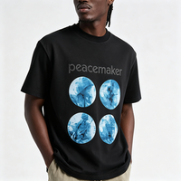 T-shirt oversize noir pour homme avec imprimé lettres en strass Peacemaker et cercle abstrait bleu, style streetwear décontracté