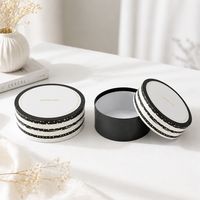 Caja Redonda Negra de Cartón Reciclable Personalizada con Tapa Blanca y Logotipo Estampado con Puntos Dorados para Empaque de Cosméticos
