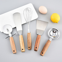 Ensemble d'ustensiles de cuisine en acier inoxydable avec manche en bois : râpe, ouvre-boîte, couteau à pizza, outils de cuisson, de découpe et de service