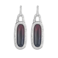 Ces boucles d'oreilles présentent un cadre ovale en résine serti de pierres en zircone cubique, alliant design moderne et éclat classique.