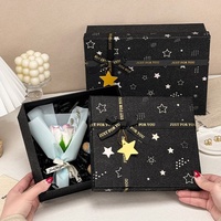 Boîte cadeau rigide à deux pièces noire avec logo personnalisé, impression étoile, paillettes, couvercle et base, avec ruban imprimé et pendentif étoile pour les fêtes