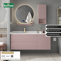Meubles-lavabos de salle de bain rose clair cannelés avec miroir rectangulaire rétroéclairé à cadre doré et comptoir étendu