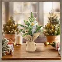 Décoration de table de Noël faite à la main avec pot en toile de jute, accents de baies dorées et branches givrées, style ferme
