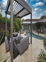 Pergola bioclimatique en aluminium imperméable avec toit à lames orientables, pour terrasse extérieure, avec option de rideaux latéraux.