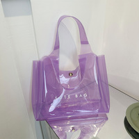 Sac de plage et de voyage transparent en PVC imperméable, petit format, avec logo personnalisé, motif lettres orange et violet, idéal pour le shopping ou comme cadeau.