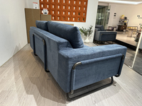 Canapé moderne minimaliste à trois places en rangée droite, avec accoudoirs en métal noir et revêtement en velours bleu marine compressé, idéal pour villa ou appartement