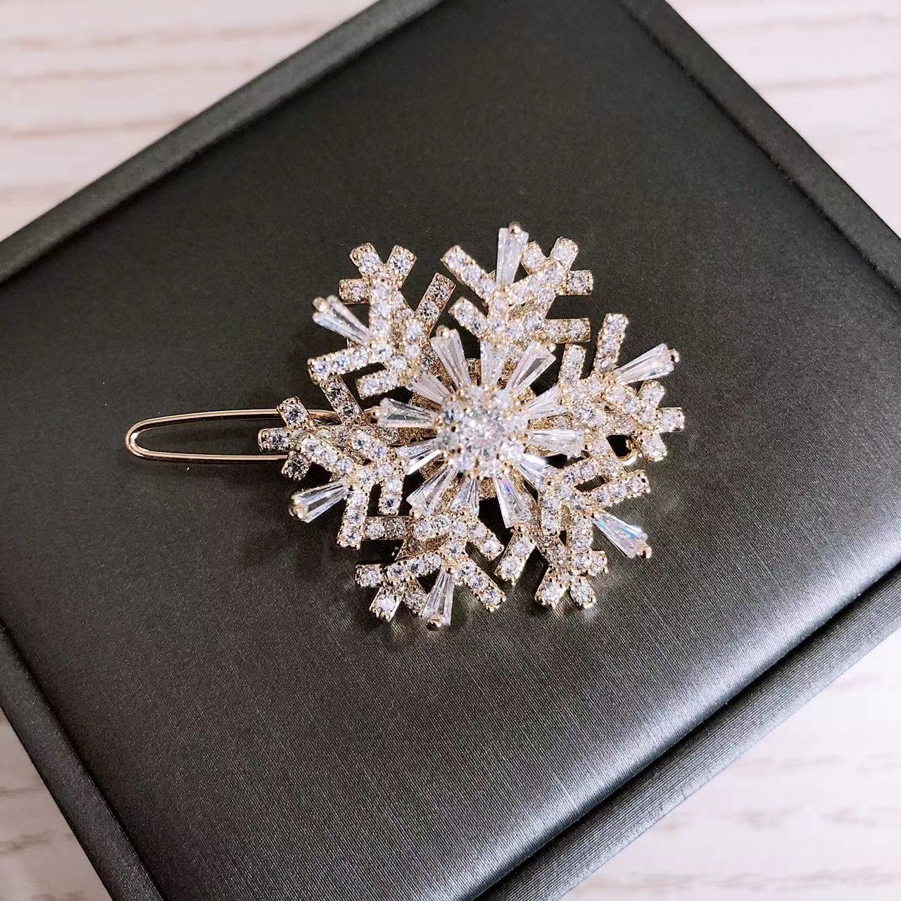 Pinza para el cabello con forma de copo de nieve dorado.