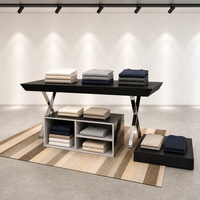 Table de présentation noire avec pieds en X chromés, meuble îlot bas commercial pour vêtements