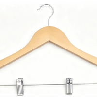 Cintre en bois naturel de haute qualité avec épaules larges et pinces métalliques pour l'organisation de placards de luxe