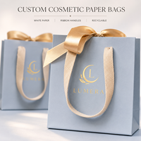 Sacs shopping en papier blanc de luxe personnalisés avec poignées en ruban longues pour l'emballage de marques de cosmétiques et de produits de beauté, vente en gros
