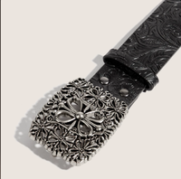 Cette ceinture rétro présente une boucle croisée en alliage noir à motifs floraux en relief et ornée de découpes argentées, d'une esthétique western classique.