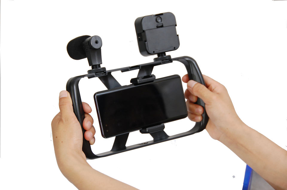Kit AY49T sostenido con ambas manos para grabación estable con celular