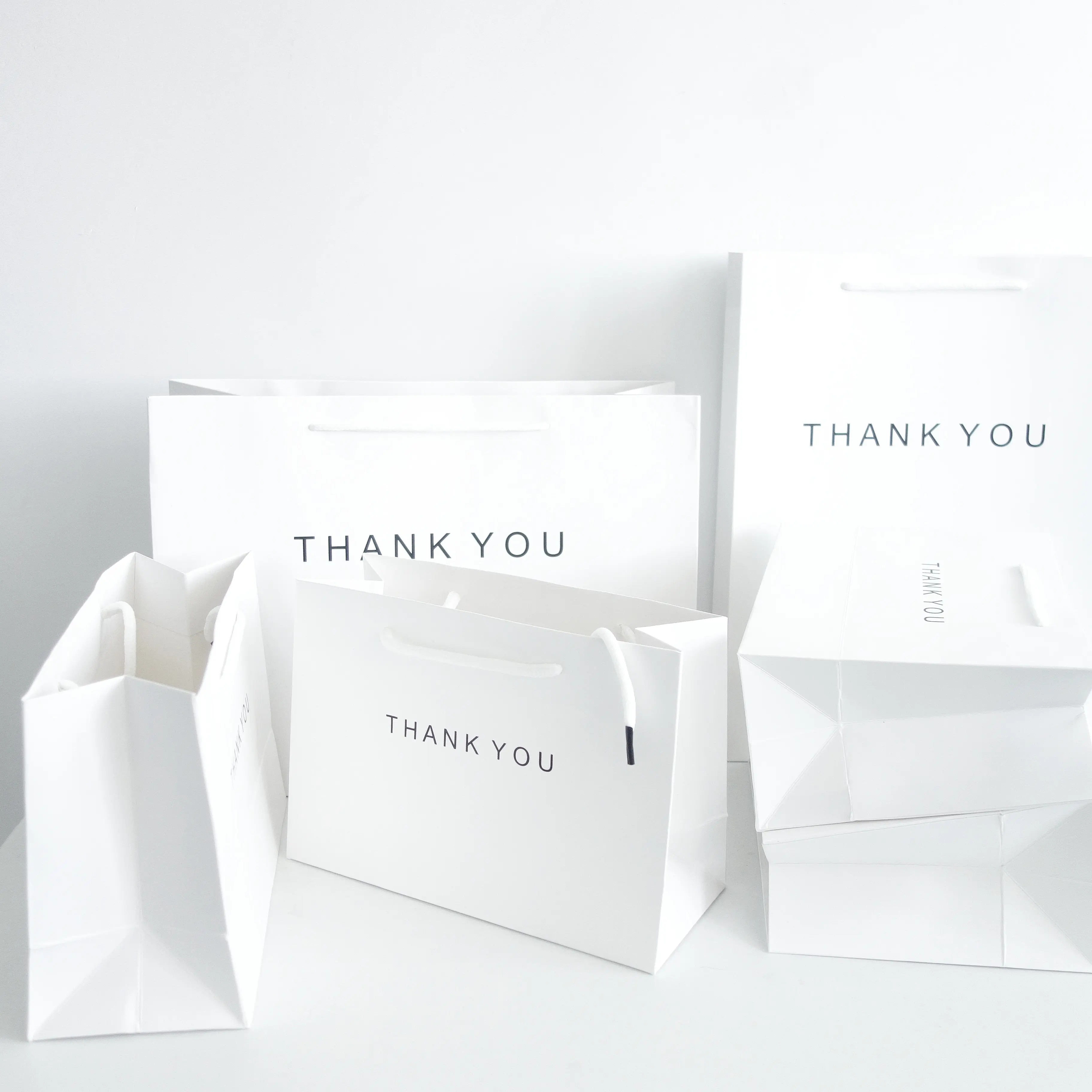 shopping gift bags Customized for logo Recycled white coated paper bag with cloth handle