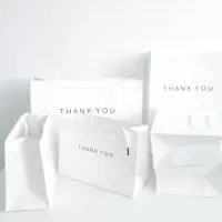 ถุงกระดาษเคลือบสีขาวรีไซเคิลพร้อมด้ามจับผ้าถุงของขวัญช้อปปิ้งที่กำหนดเองสำหรับโลโก้