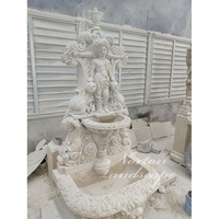 Fontaine murale décorative d'extérieur personnalisée en pierre calcaire et granit, avec sculptures de statues d'enfants et de têtes de lion sculptées