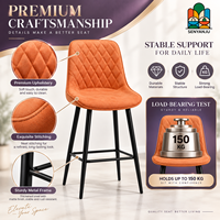 Tabouret de bar en cuir orange matelassé avec dossier en losanges, quatre pieds en métal noir, repose-pieds, hauteur de comptoir