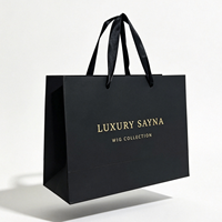 Sacs shopping en papier noir mat élégants avec logo personnalisé, impression dorée à chaud, et poignées en ruban pour l'emballage de perruques en boutique