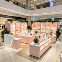 Ensemble de présentoirs de magasin de beauté rose, table d'îlot cosmétique à LED arquée, vitrine murale, équipements personnalisés