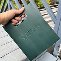 Sac cadeau en papier mat laminé vert foncé avec logo en relief découpé et couvercle plat, fourni par le fabricant