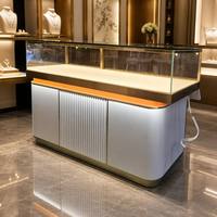 Table de présentation de bijoux incurvée moderne sur mesure, base argentée, bordure dorée, vitrine en verre pour magasin de diamants, d'or et de jade