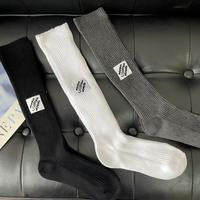 Chaussettes unisexes mi-mollet à texture côtelée avec logo patch, chaussettes streetwear décontractées, couleur noire, chaussettes tendance polyvalentes, chic urbain