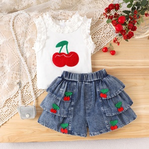 Abbigliamento estivo per bambina, completo due pezzi con top senza maniche con stampa ciliegie e volant e pantaloncini in denim a balze. - Product Image 1