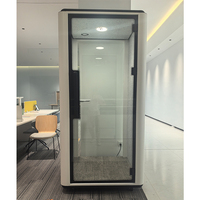 Cabine insonorisée avec porte en verre à cadre foncé, éclairage LED, panneau acoustique, espace calme pour la concentration en bureau ouvert