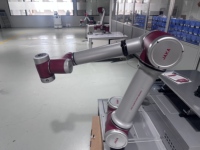 Station d'asservissement de machine robuste intégrée au cobot JAKA, avec trémie pour produits finis et effets-fins polyvalents, bras robotisé CNC