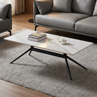 Table basse moderne en marbre blanc avec base araignée en métal noir élégante pour un bureau ou un salon minimaliste de luxe