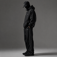 Ensemble de survêtement coupe-vent personnalisé pour homme en nylon noir, veste à capuche et pantalon large avec passepoil blanc, style streetwear et sportif