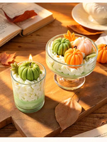 Simulierte Kürbis-Duftkerze in Creme-Optik im Glasbecher für Herbst-Atmosphäre und Halloween-Tischdekoration