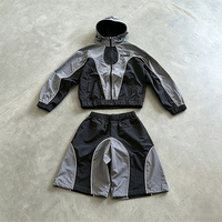 Ensemble de survêtement OEM personnalisé en nylon imperméable avec bandes réfléchissantes, patchwork incurvé, veste à capuche zippée et pantalon de jogging – Vente en gros
