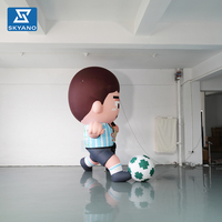 Modèle de personnage gonflable personnalisé de garçon jouant au football pour la décoration publicitaire d'événements sportifs en extérieur et de sites touristiques