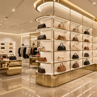 Vitrine de présentation de sacs à main en acier inoxydable doré de luxe sur mesure avec éclairage LED incurvé pour boutique de détail