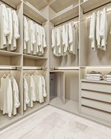 Système de dressing sur mesure haut de gamme Vermonhouzz avec îlot central en verre et zones de rangement modulaires avec éclairage artistique au plafond