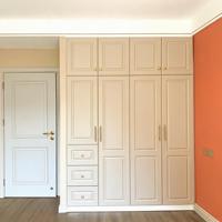 Armoire moderne minimaliste beige avec tiroirs et portes battantes, poignées dorées, pour chambre à coucher
