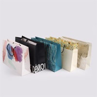 Sacs en papier kraft de luxe avec poignée en ruban Emballage de luxe imprimé personnalisé pour vêtements Cadeaux au détail bon marché du fournisseur