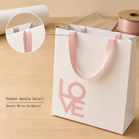 Sac en papier blanc personnalisé avec poignées en ruban rose et face imprimée pour emballage cadeau de détail, acheteurs en gros
